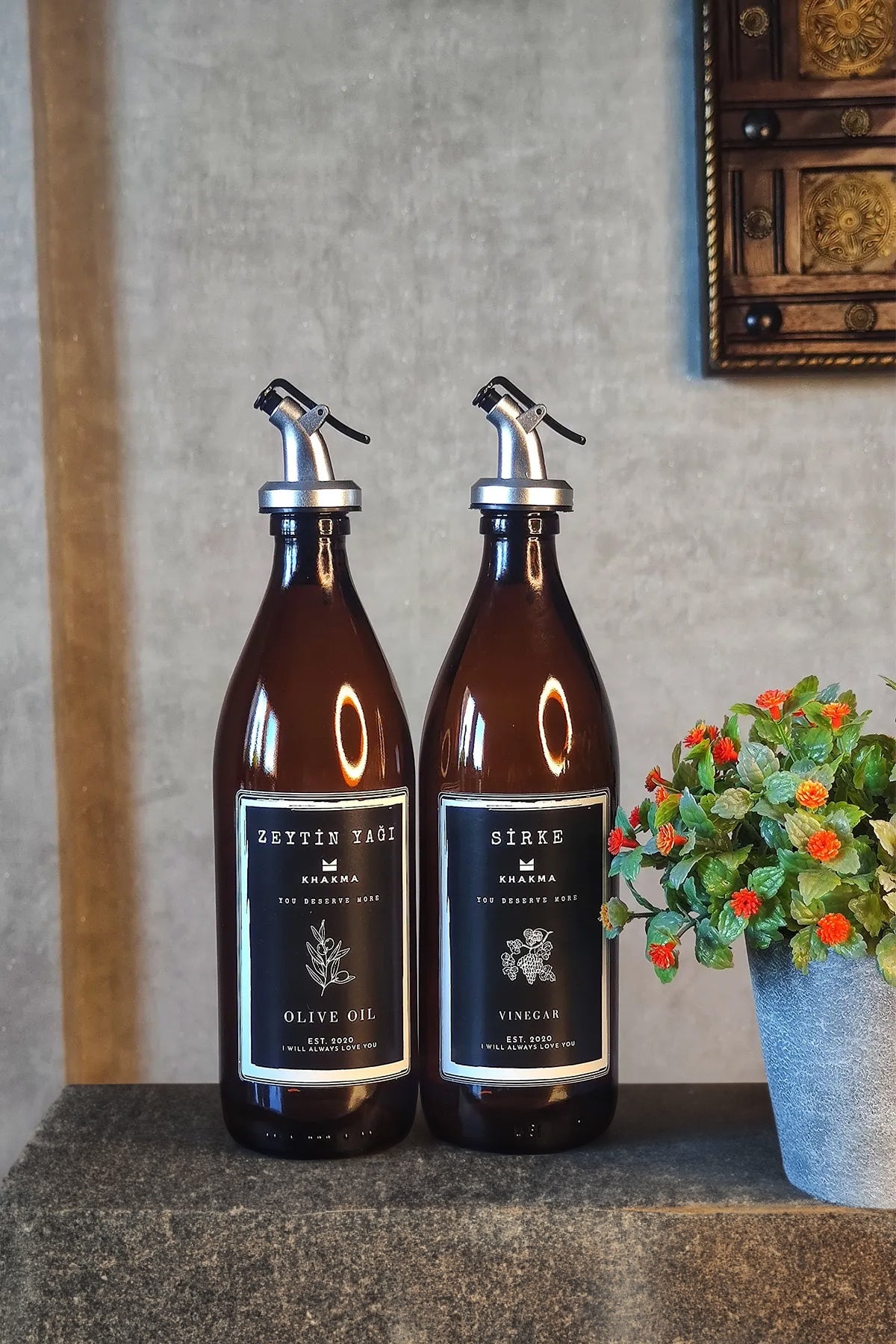 Taş zemin üzerinde çiçek saksısı yanında 2'li 500 ml amber cam yağdanlık seti