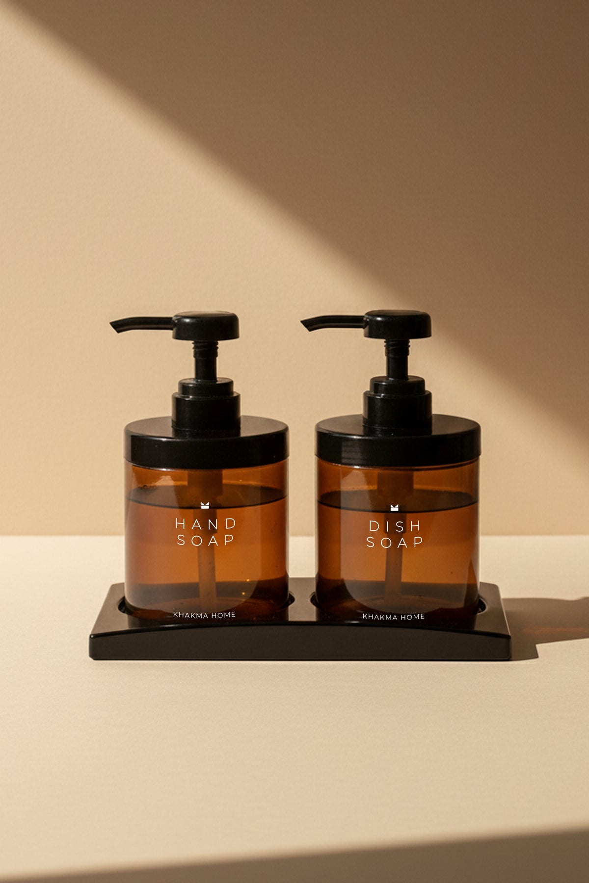 Siyah stand üzerinde Hand Soap ve Dish Soap baskılı 2'li amber cam sabunluk seti