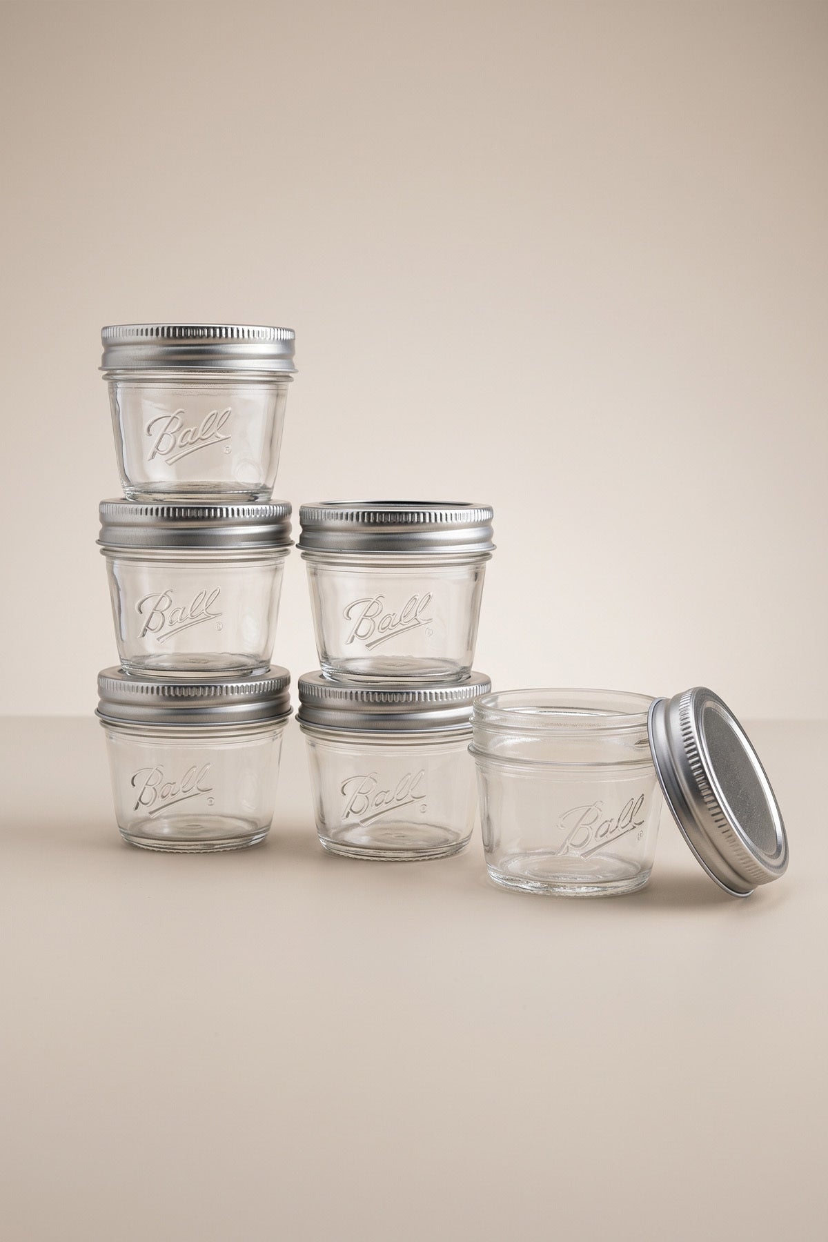 Metal kapaklı altı adet boş 100 ml cam mini kavanoz, biri kapağı açık