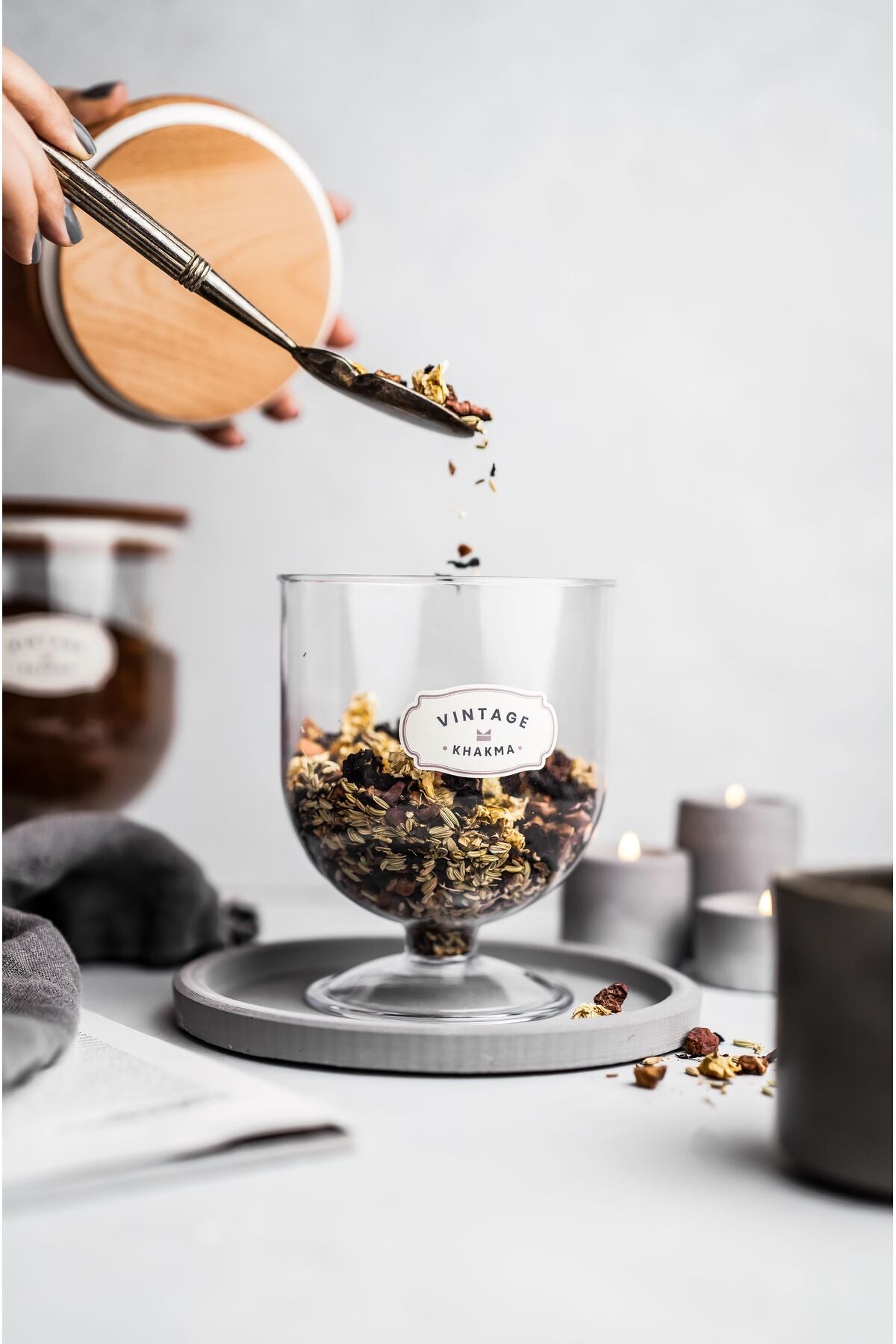 Ayaklı saklama kabına kaşıkla granola ve kuru meyve ekleme