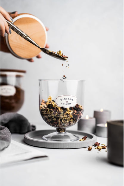 Ayaklı saklama kabına kaşıkla granola ve kuru meyve ekleme