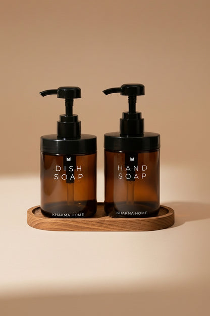 Ahşap stand üzerinde Dish Soap ve Hand Soap yazılı iki amber cam pompalı sabunluk