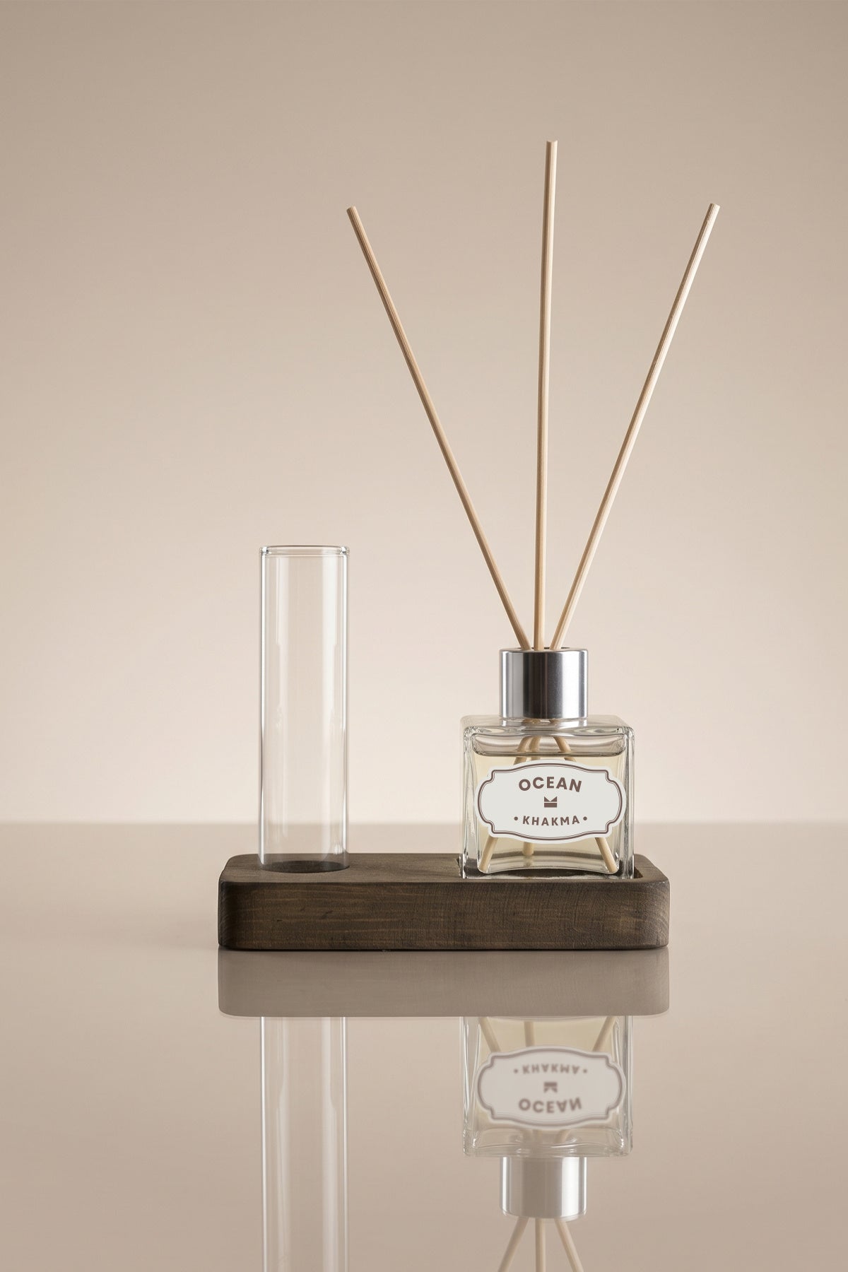Ahşap stant üzerinde 50 ml Ocean difüzör şişesi, bambu çubuklar ve boş cam tüp vazo