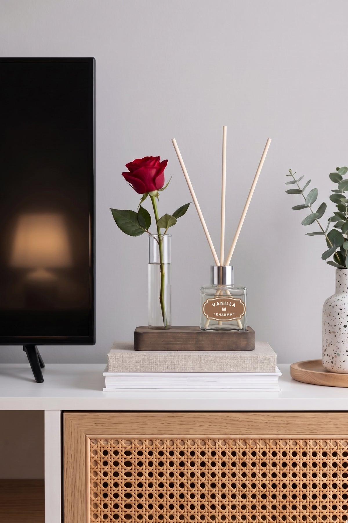 TV ünitesinde kırmızı gül ile dekore edilmiş ahşap standlı mini oda kokusu