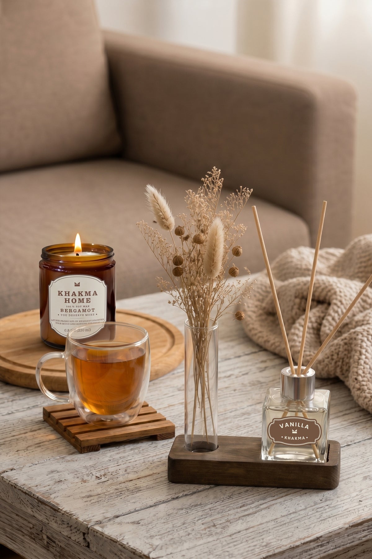 Salon sehpasında mum ve çay bardağıyla birlikte ahşap standlı mini difüzör