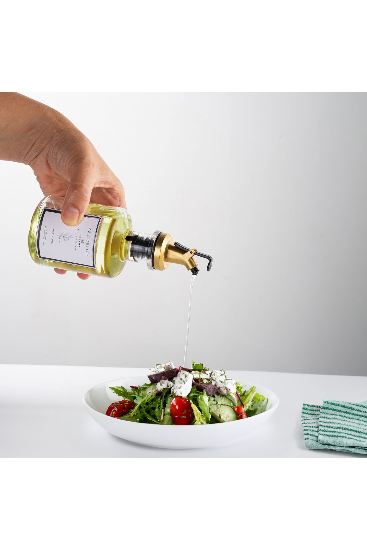 Gold damlatmaz başlıklı yağdanlıkla salataya zeytinyağı dökülmesi