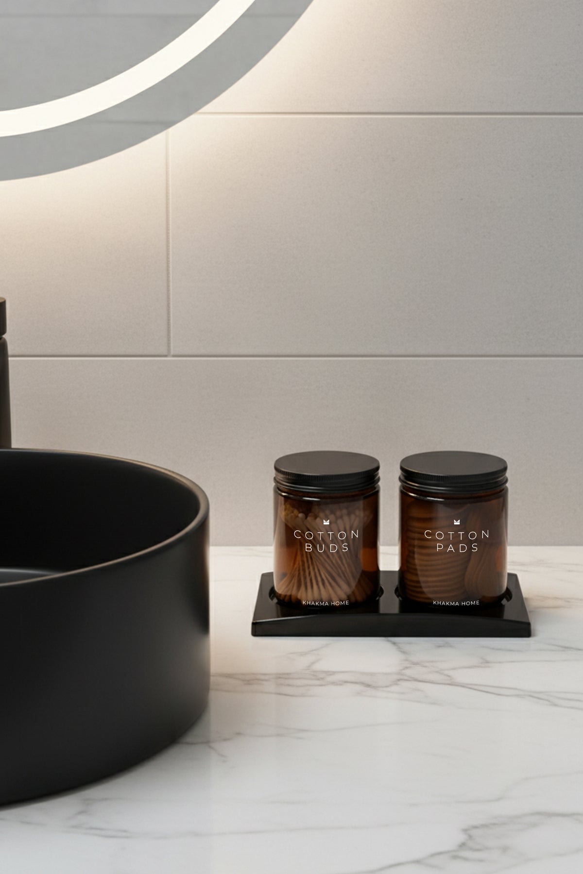 Siyah lavabo yanında mermer tezgâhta standlı amber cam pamukluk seti