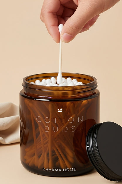 Cotton Buds yazılı amber cam kavanozdan kulak çubuğu alan el