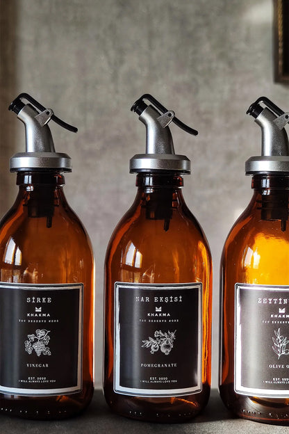 Sirke, nar ekşisi ve zeytinyağı siyah etiketli 300 ml amber şişelerin yakın çekimi