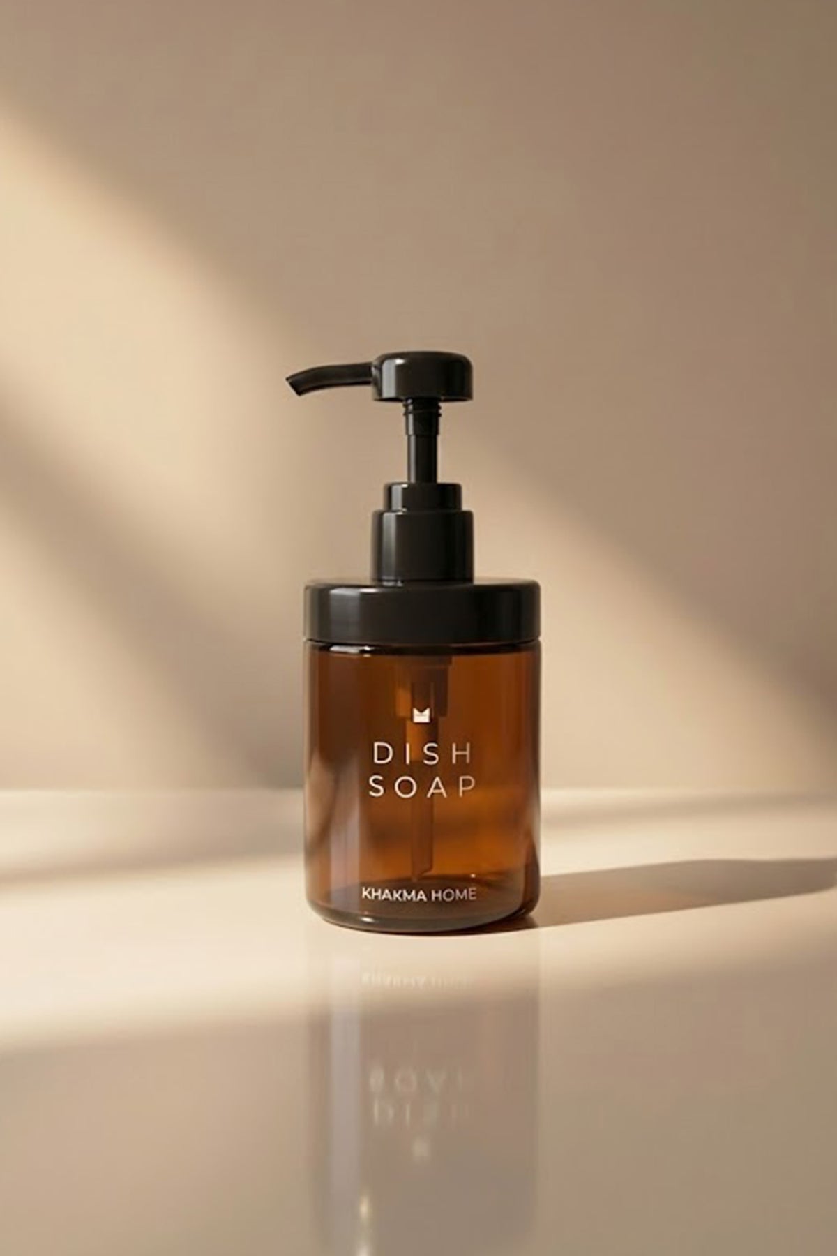 Güneş ışığında tezgâh üzerinde Dish Soap yazılı amber cam pompalı deterjanlık