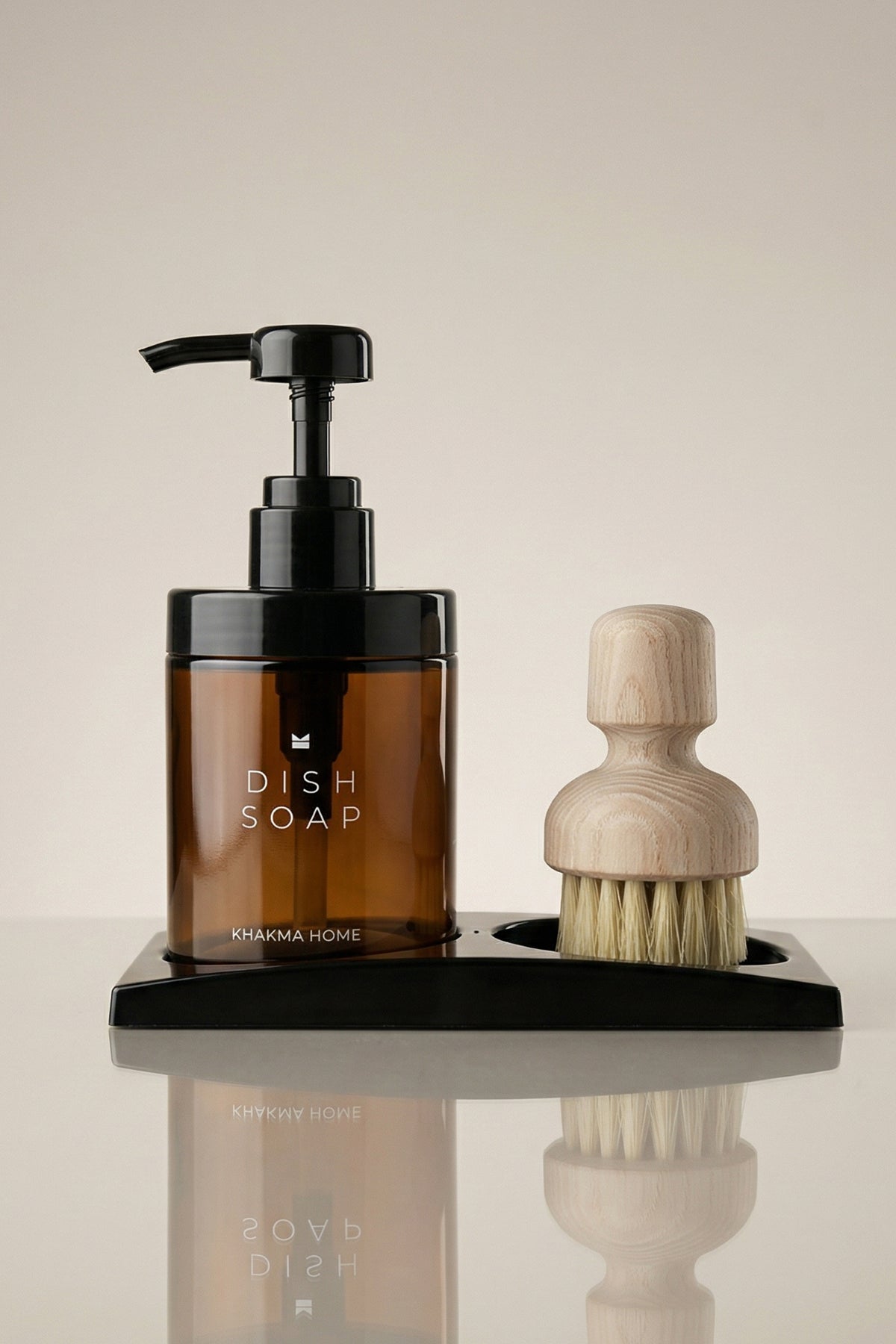 Siyah stand üzerinde Dish Soap etiketli amber cam deterjanlık ve ahşap saplı fırça