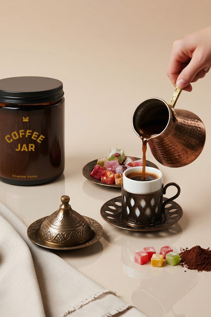 Cezveden Türk kahvesi dökülürken yanında duran amber cam Coffee Jar