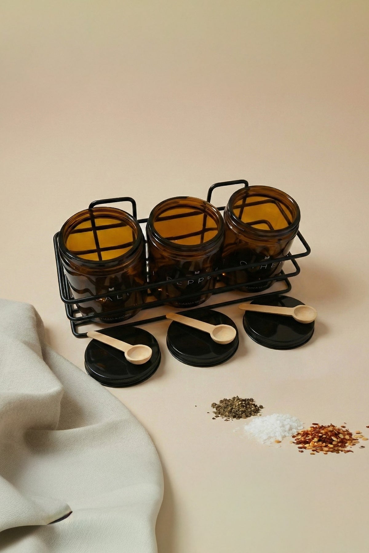 Kapakları açık amber cam kavanozlar metal standda, kapaklar üzerinde tahta kaşıklar