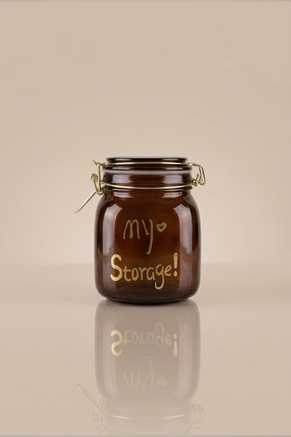 Kapağı kapalı, altın rengi my Storage yazılı 1000 ml kilitli kapaklı amber cam kavanoz