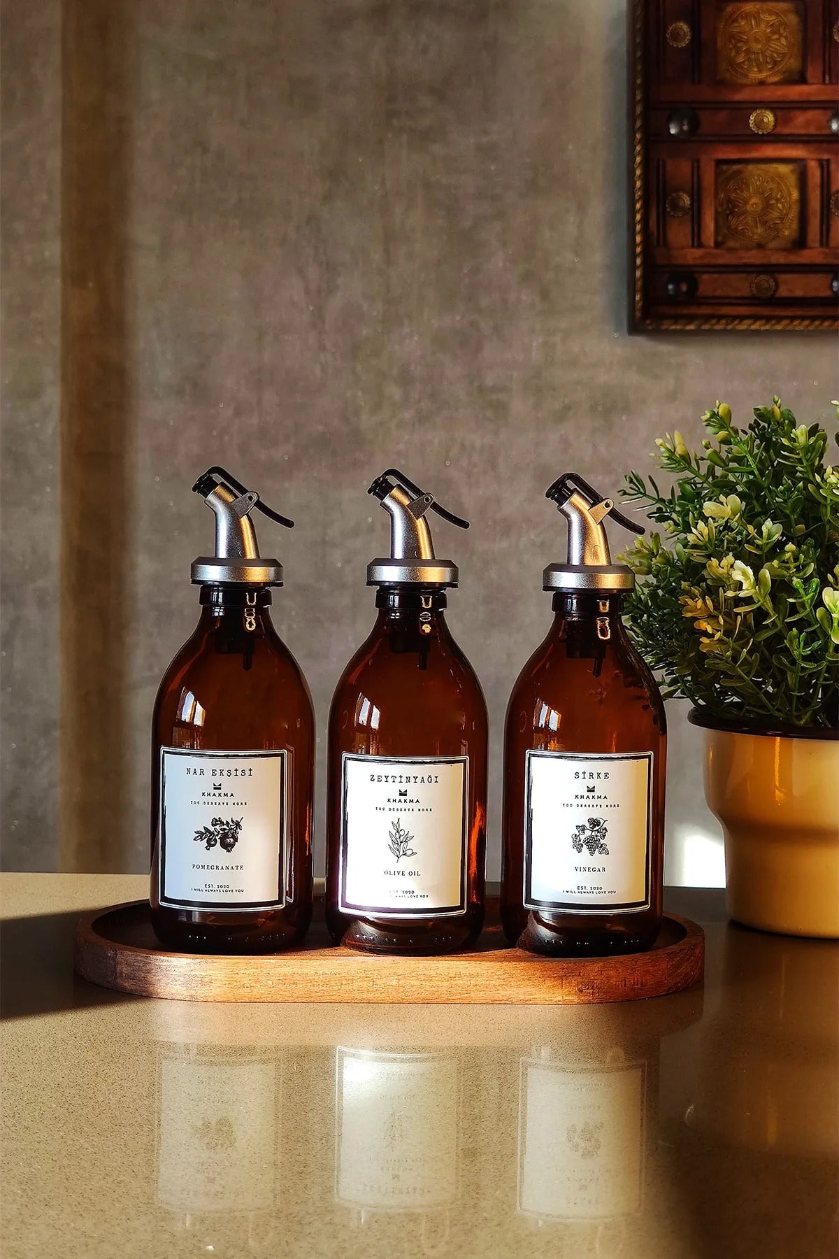 Tezgâhta oval ceviz renkli stantta 300 ml amber yağdanlıklar, önden görünüm