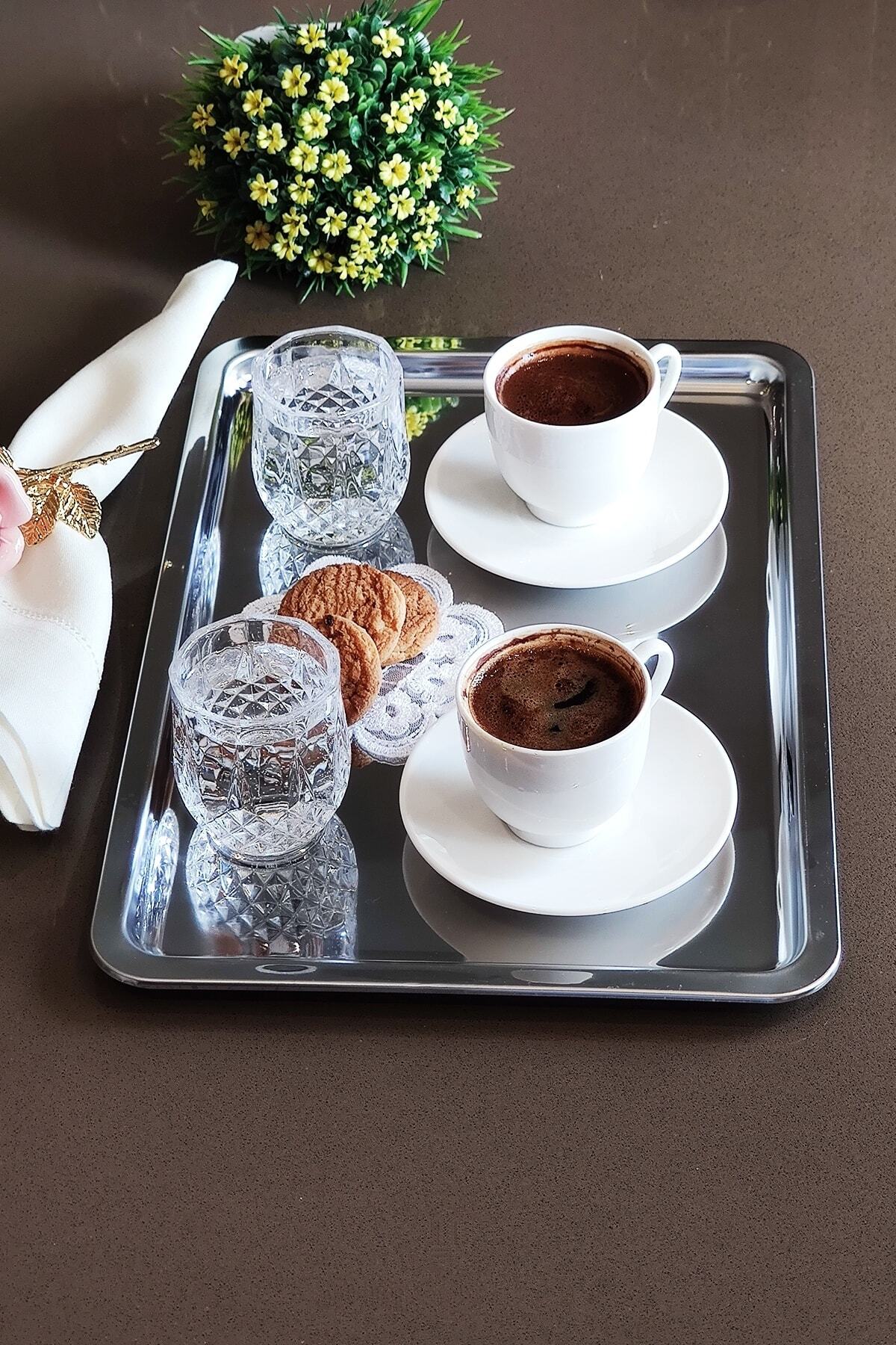İki Türk kahvesi, kristal su bardakları ve kurabiye servis edilen çelik tepsi