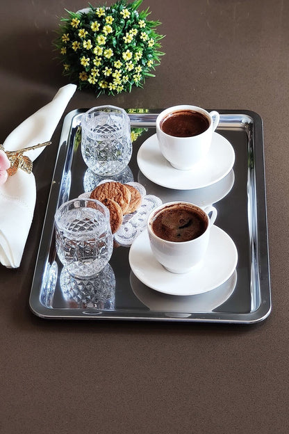 İki Türk kahvesi, kristal su bardakları ve kurabiye servis edilen çelik tepsi