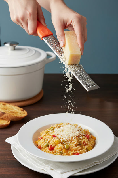 Risotto tabağının üstüne ince el rendesiyle parmesan rendeleniyor