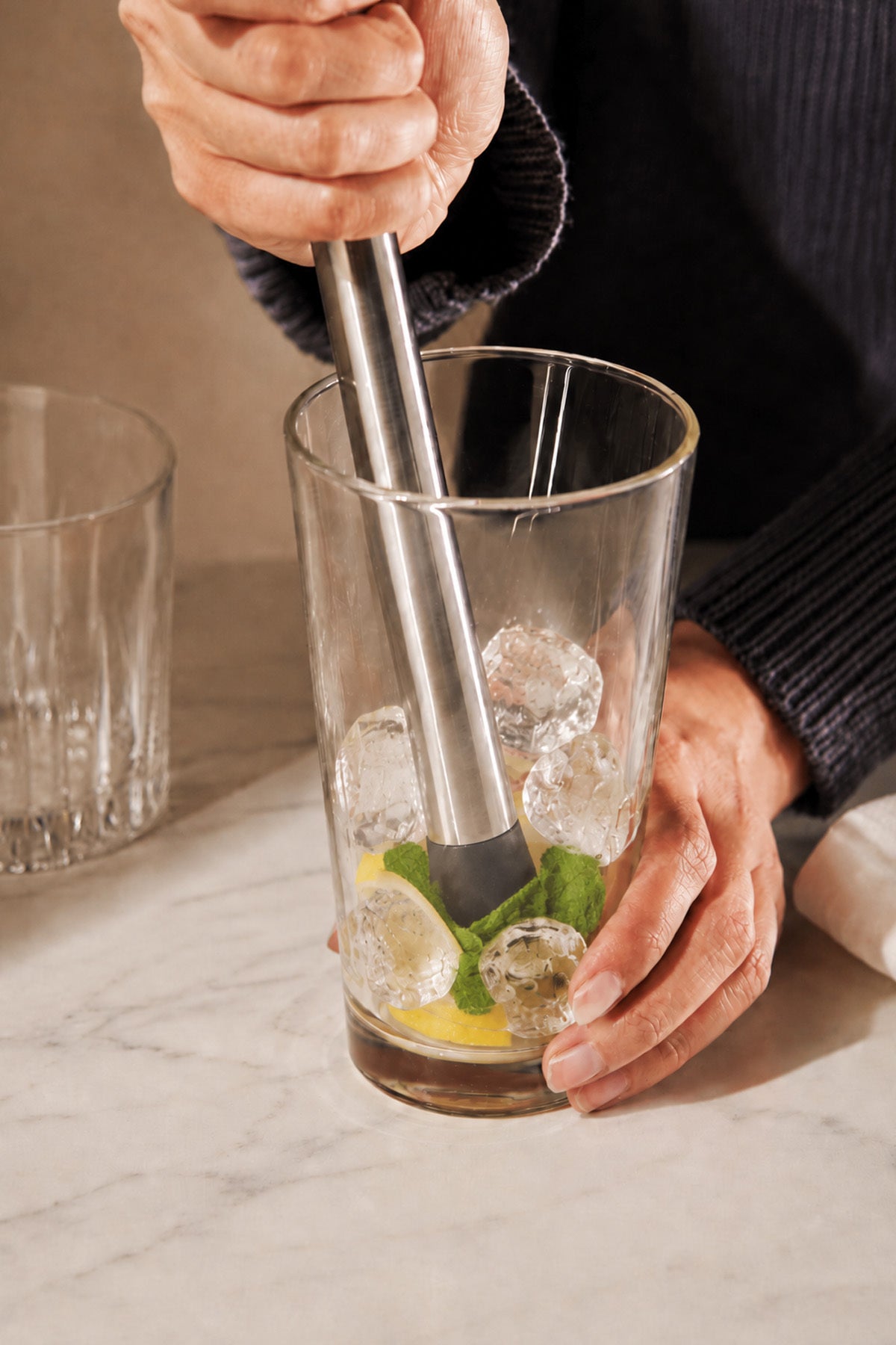 Buzlu bardakta limon ve naneyi ezen paslanmaz çelik kokteyl ezici