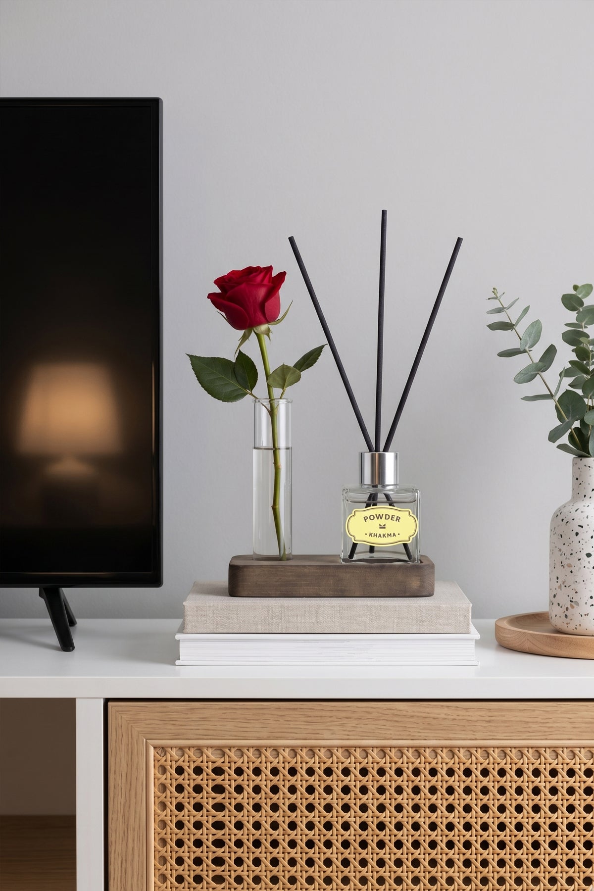 TV ünitesinde kırmızı gül süslü cam tüplü mini difüzör seti