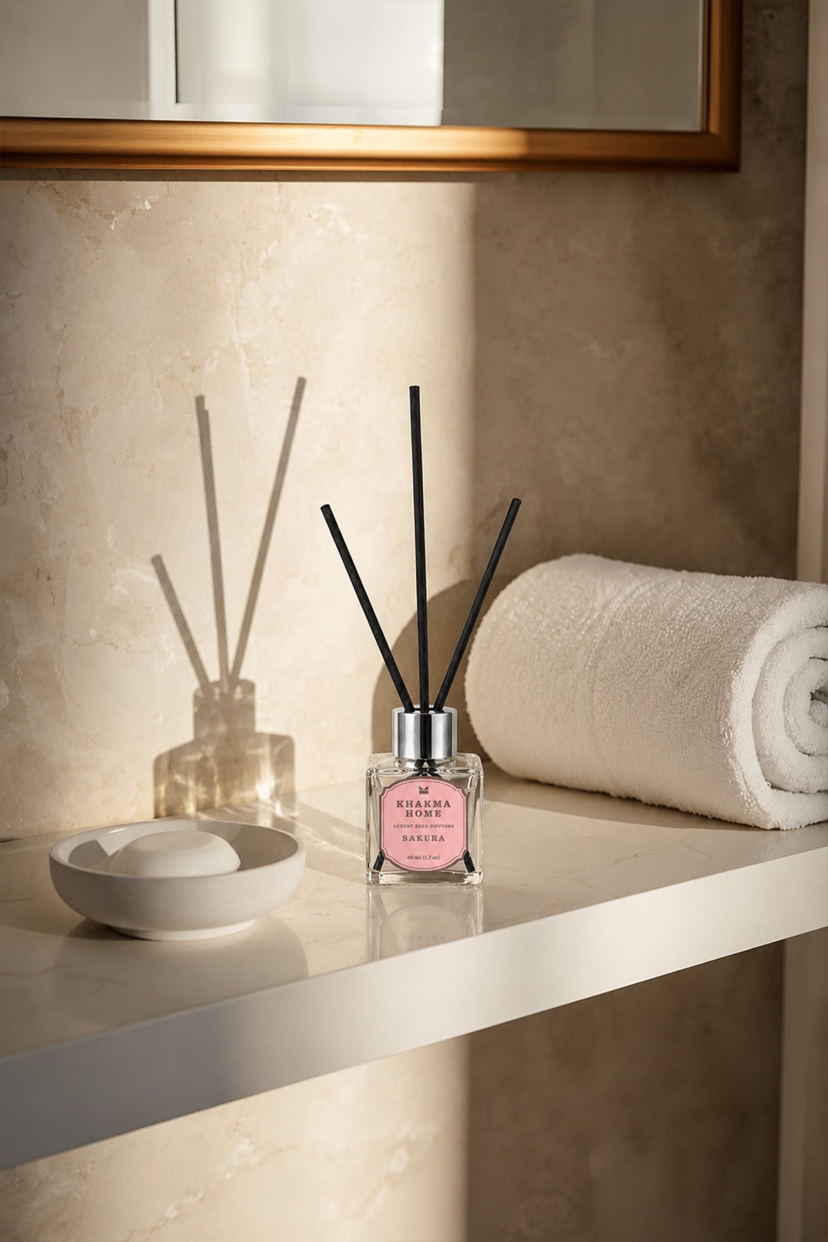 Banyo rafında havlu ve sabun yanında duran 50 ml Sakura oda kokusu
