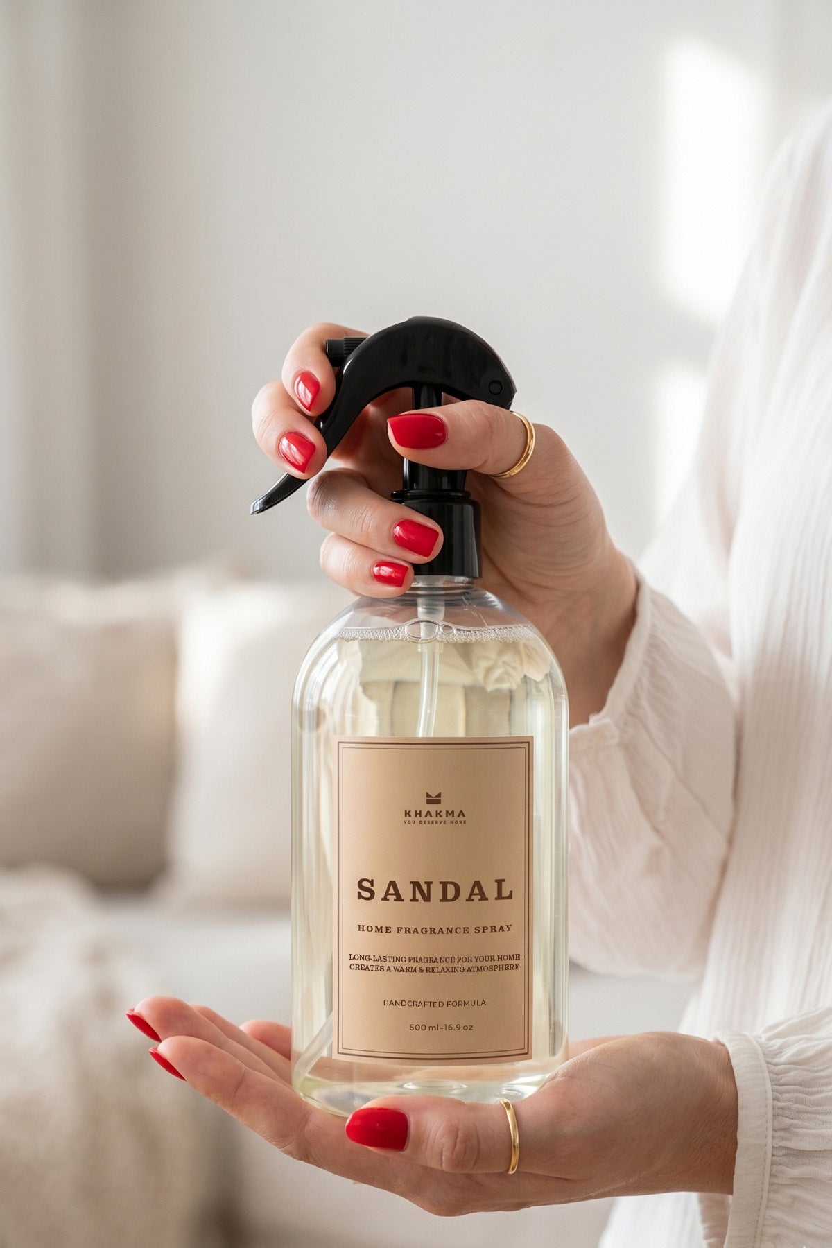 Elinde 500 ml sandal ağacı kokulu oda spreyi tutan kadın