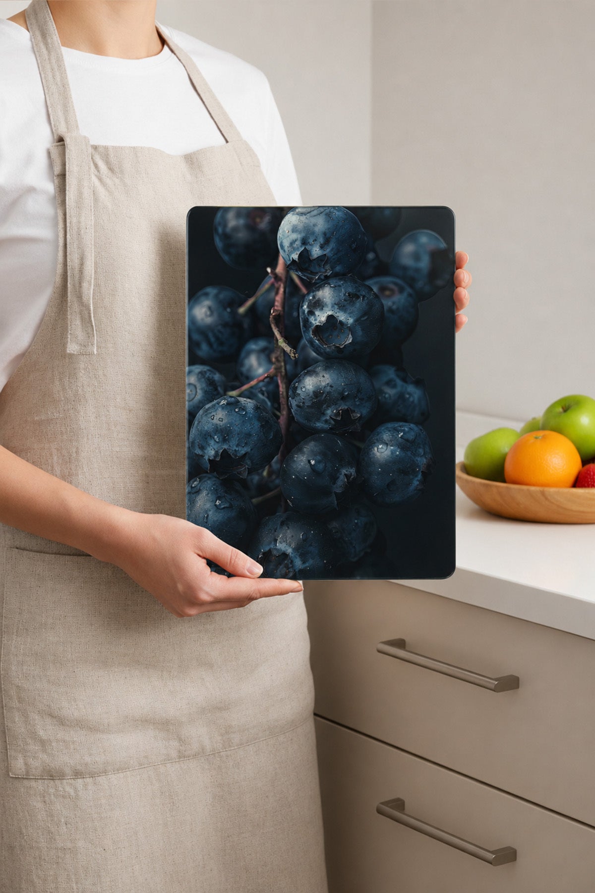 Önlüklü kişinin elinde tuttuğu 25x35 cm yaban mersini desenli cam kesme tahtası
