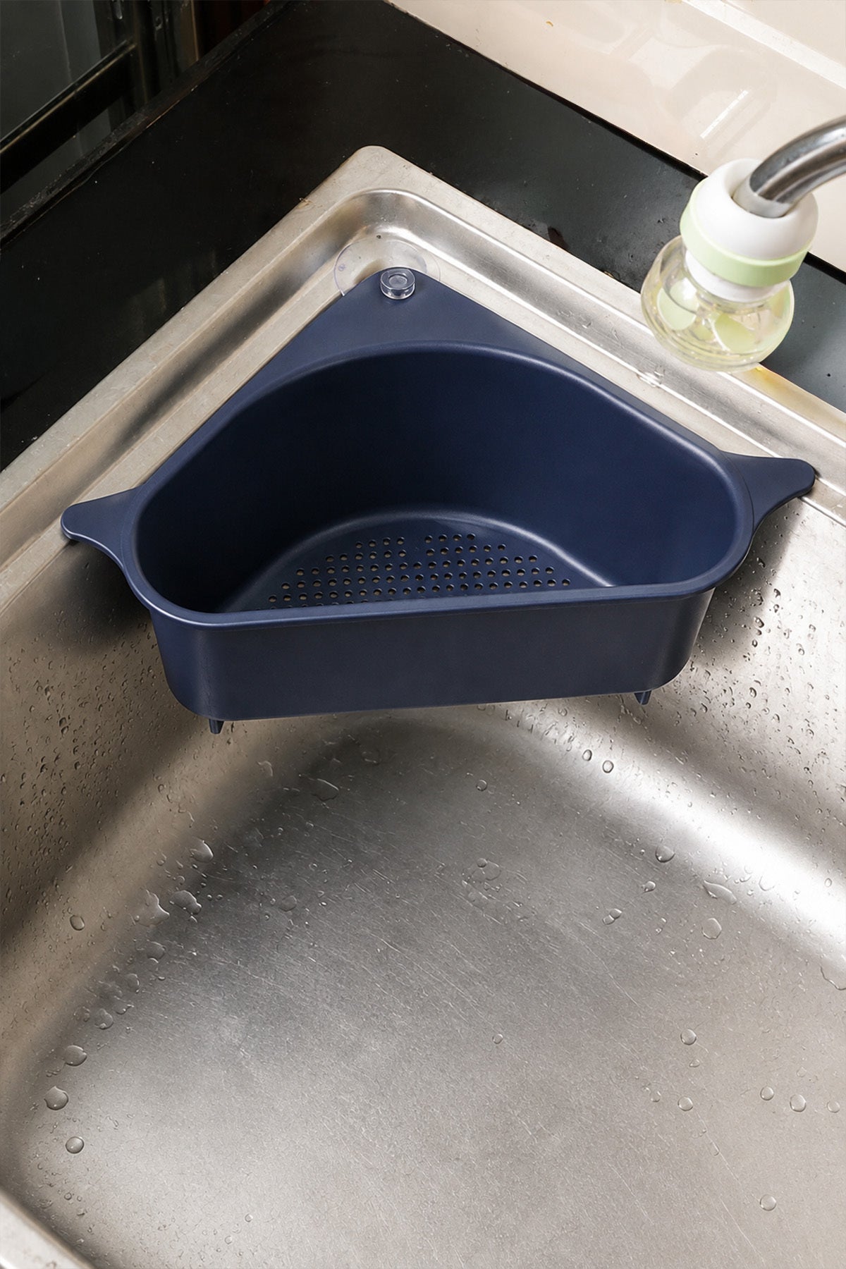 Çelik evyenin köşesine vantuzla sabitlenmiş lacivert lavabo köşe düzenleyici
