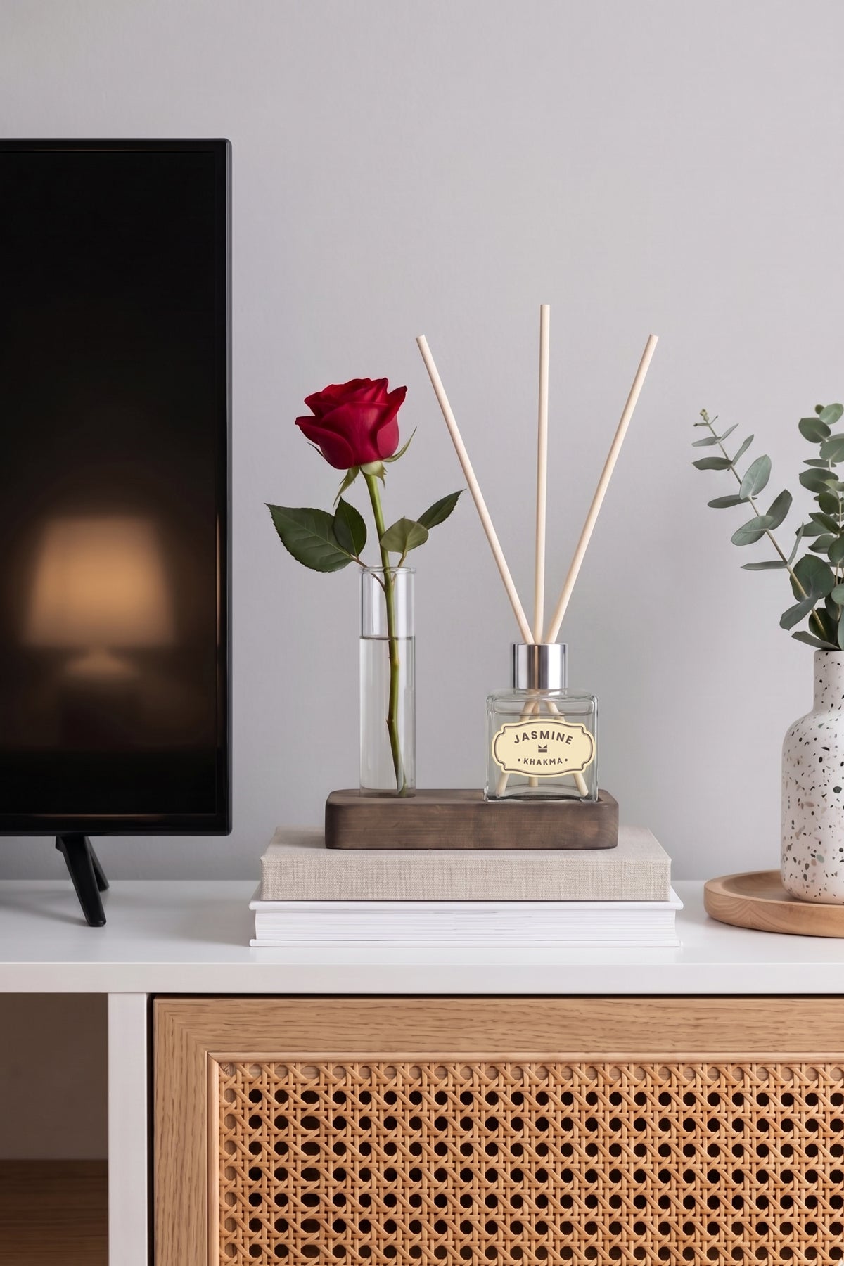 TV ünitesi üzerinde kırmızı güllü ahşap standlı mini oda kokusu seti